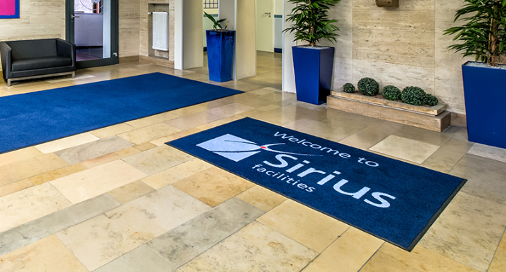 Bedruckte Fußmatte mit Sirius Facilities Logo im Eingangsbereich