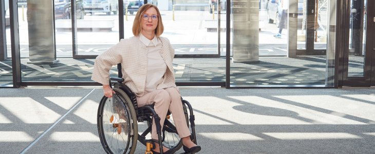 Frau in Rollstuhl im barrierefreien ebenerdigen Eingangsbereich